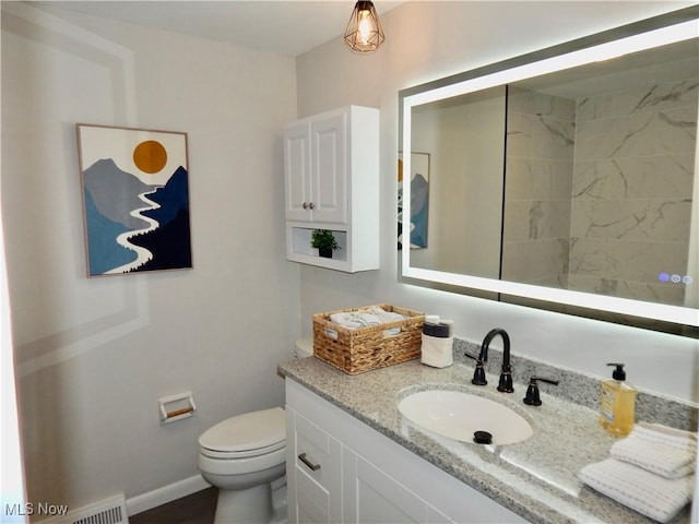 bathroom with visible vents, baseboards, vanity, and toilet