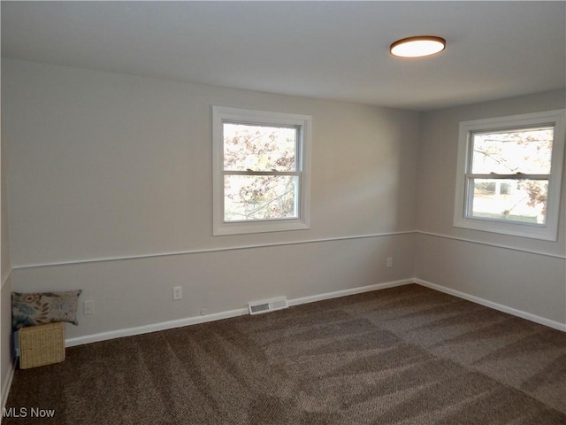 carpeted empty room featuring visible vents and baseboards