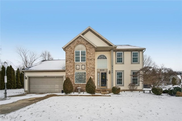 traditional-style home with a garage and brick siding