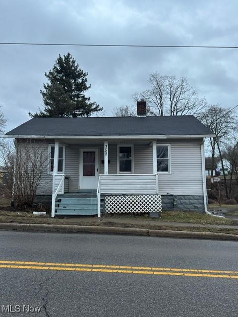 view of front of property with a porch and a chimney