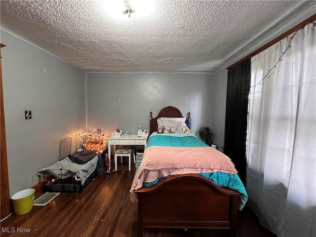 bedroom with a textured ceiling and wood finished floors