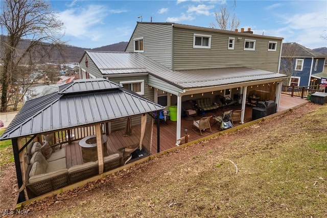 rear view of property featuring a gazebo, metal roof, and a wooden deck