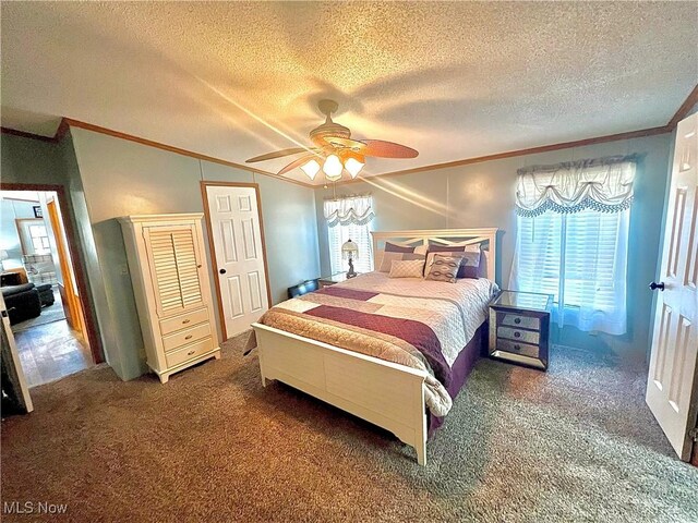 carpeted bedroom with ceiling fan, a textured ceiling, and crown molding