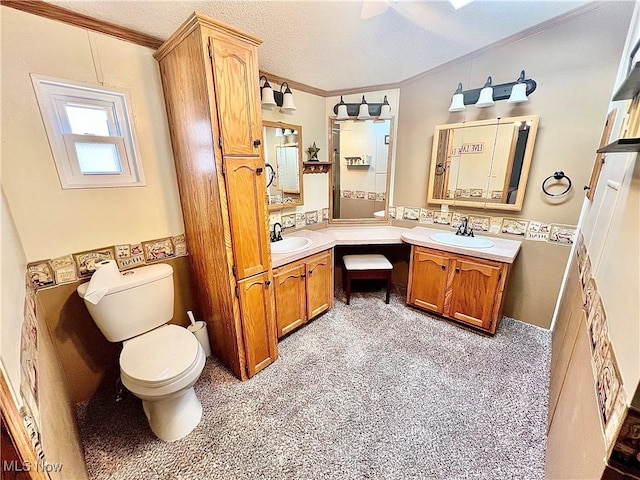bathroom featuring ornamental molding, vanity, toilet, and a textured ceiling