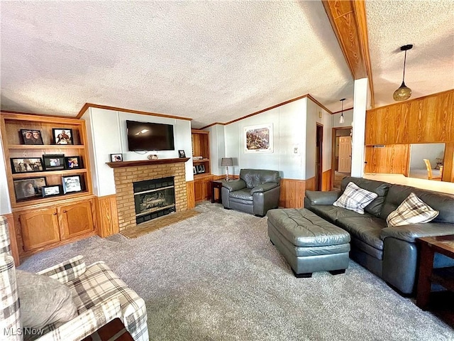 living area featuring wainscoting, lofted ceiling with beams, a textured ceiling, carpet flooring, and a brick fireplace