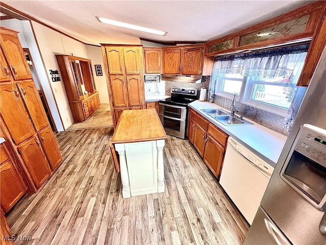 kitchen with brown cabinetry, a sink, white dishwasher, light wood-type flooring, and double oven range
