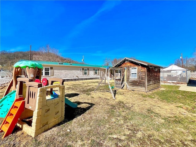 view of playground with an outbuilding and fence
