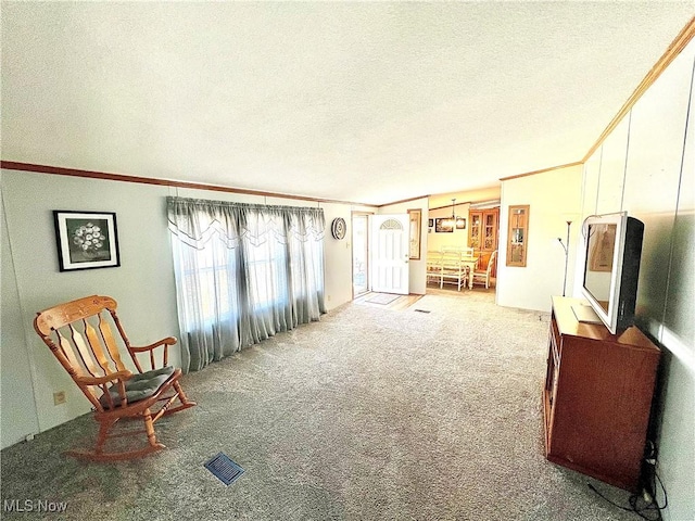 living area featuring ornamental molding, carpet, visible vents, and a textured ceiling