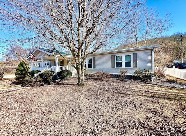 ranch-style house with covered porch and fence