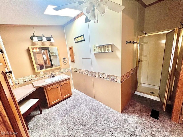 full bath with ornamental molding, a skylight, a shower stall, and vanity