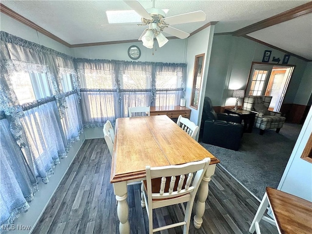 dining room with vaulted ceiling with beams, a healthy amount of sunlight, a textured ceiling, and wood finished floors