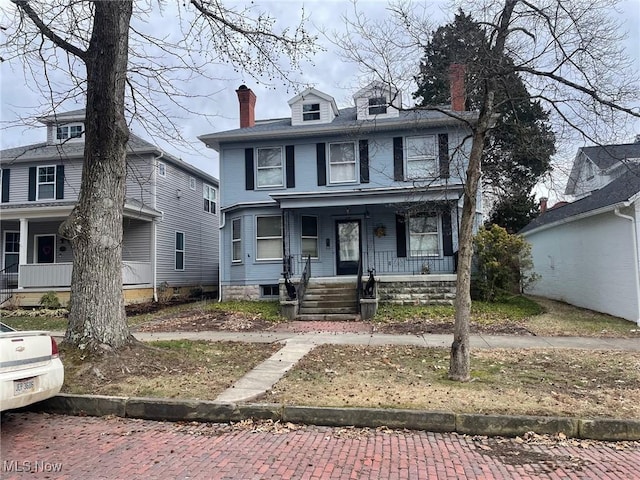 traditional style home featuring a porch and a chimney