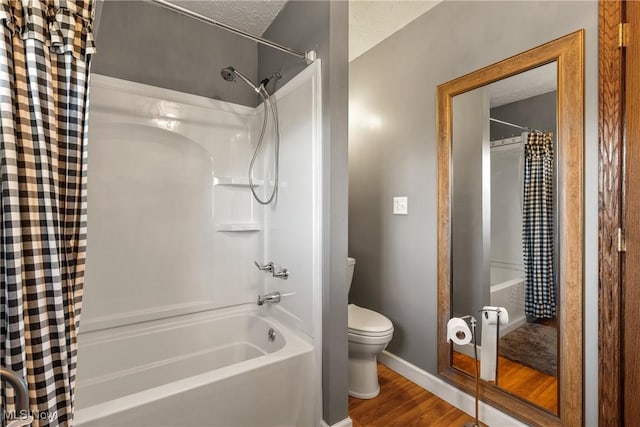 bathroom featuring toilet, shower / bath combo, baseboards, and wood finished floors