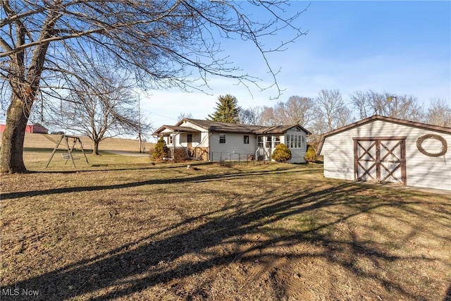 view of front facade featuring an outbuilding, driveway, a front lawn, and a garage