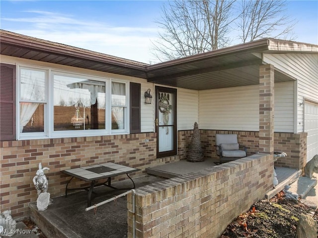 doorway to property with brick siding and an attached garage