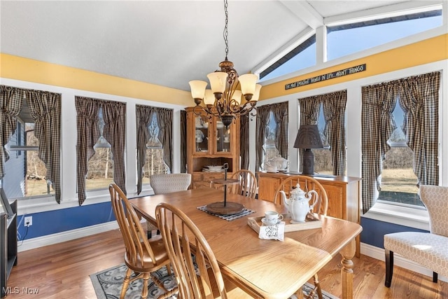 dining space with a chandelier, baseboards, vaulted ceiling with beams, and light wood finished floors