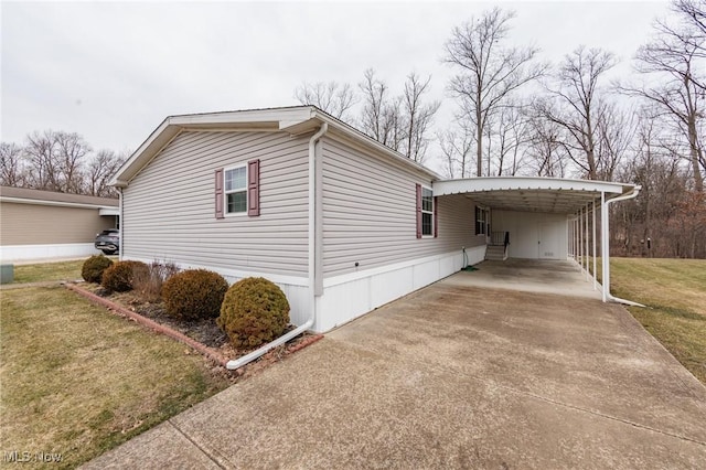 view of side of property featuring a carport, concrete driveway, and a lawn