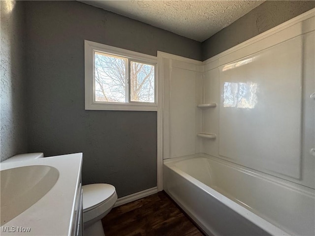 full bath with baseboards, toilet, wood finished floors, a textured ceiling, and vanity