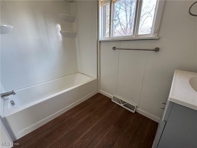 bathroom featuring shower / bath combination, baseboards, visible vents, wood finished floors, and vanity