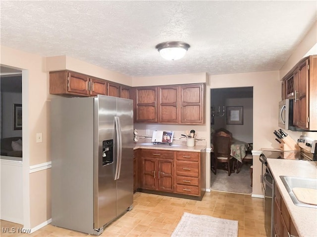 kitchen featuring a textured ceiling, light countertops, and appliances with stainless steel finishes