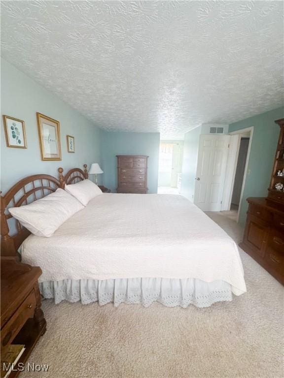 carpeted bedroom featuring a textured ceiling