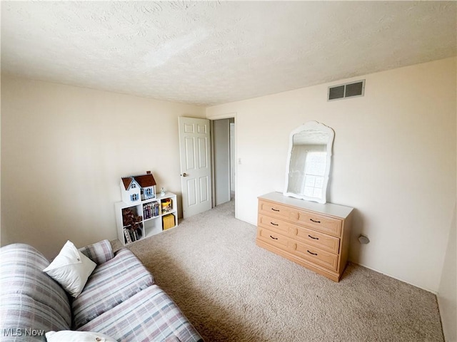 living area with visible vents, light carpet, and a textured ceiling