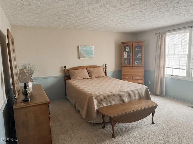 bedroom featuring light carpet and a textured ceiling