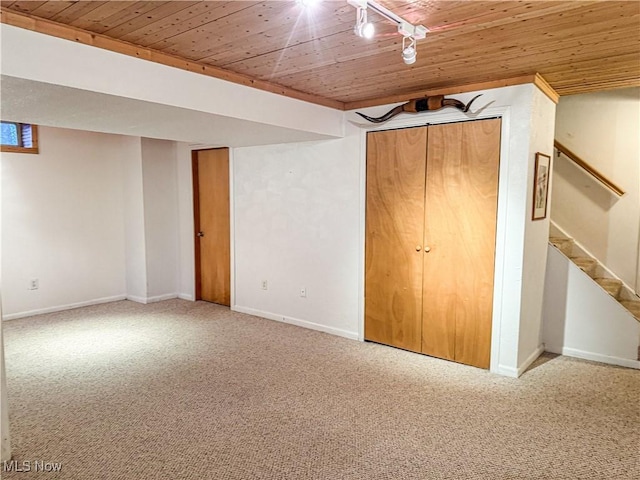 unfurnished bedroom featuring wooden ceiling, baseboards, carpet flooring, and rail lighting