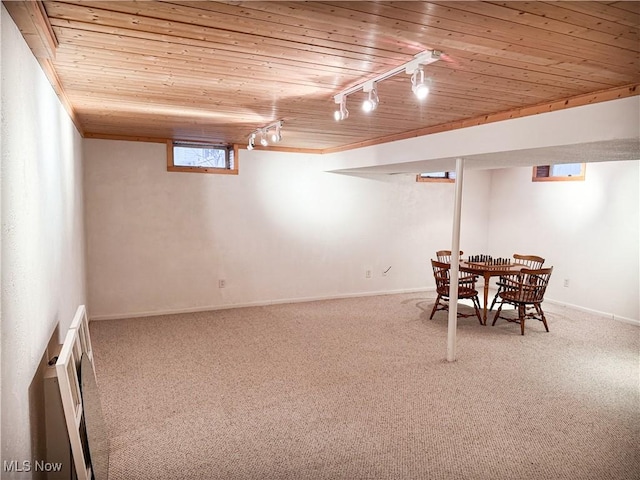 interior space featuring carpet floors, track lighting, wooden ceiling, and baseboards