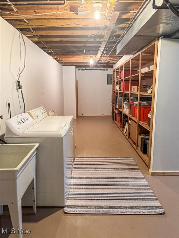 clothes washing area featuring a sink, laundry area, washing machine and dryer, and electric panel