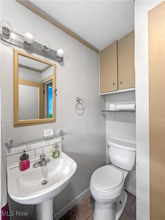 471 E N Ave, East Palestine, OH 44413 - half bath featuring toilet, baseboards, tile patterned floors, and a sink