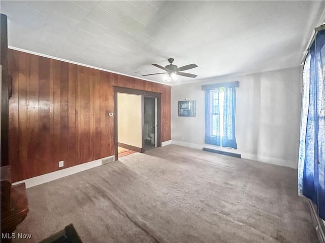 471 E N Ave, East Palestine, OH 44413 - empty room with a ceiling fan, wood walls, baseboards, and carpet