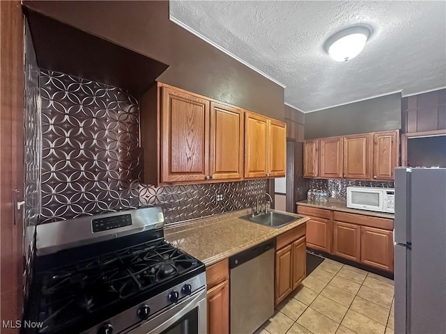 471 E N Ave, East Palestine, OH 44413 - kitchen with stainless steel appliances, a sink, a textured ceiling, backsplash, and light tile patterned floors