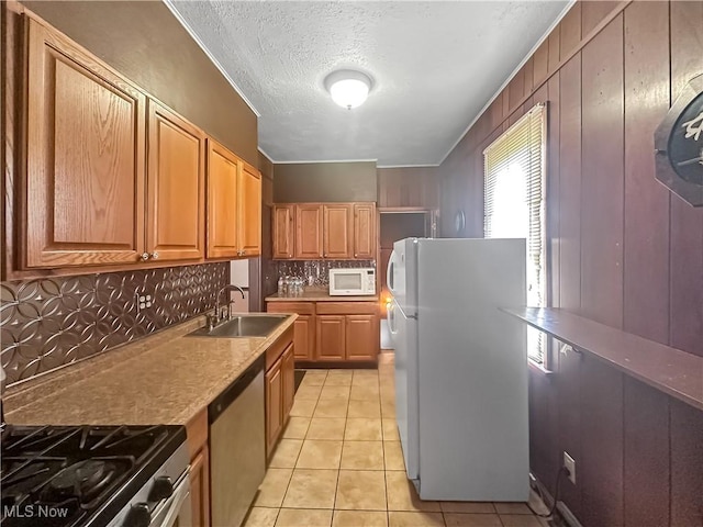 471 E N Ave, East Palestine, OH 44413 - kitchen featuring a sink, appliances with stainless steel finishes, backsplash, light tile patterned flooring, and a textured ceiling