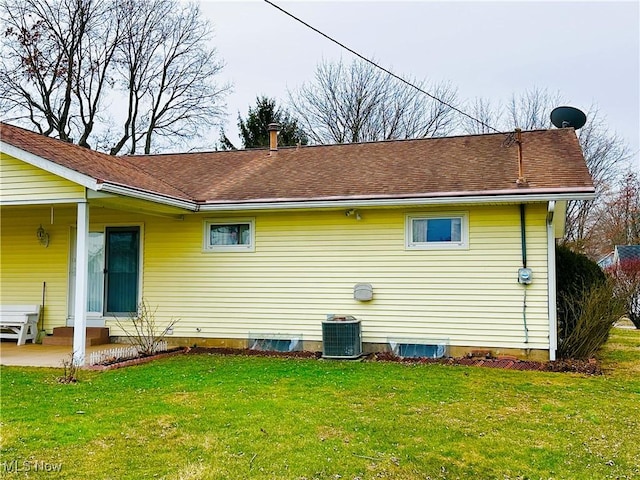 view of side of home with entry steps, a yard, and central AC unit