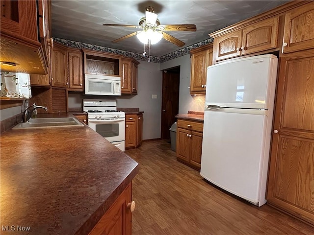 kitchen featuring white appliances, a sink, brown cabinets, open shelves, and dark countertops