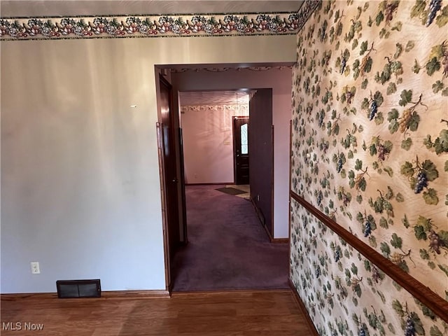 hall featuring baseboards and wood finished floors