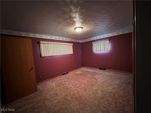 carpeted empty room with baseboards