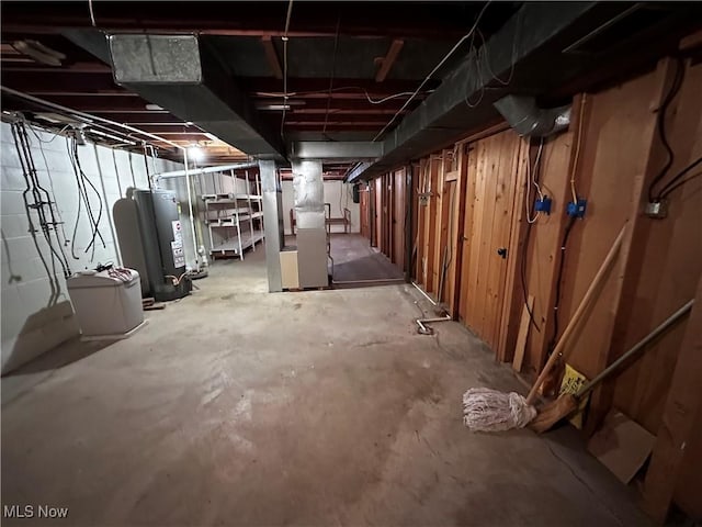 unfinished below grade area featuring water heater and heating unit