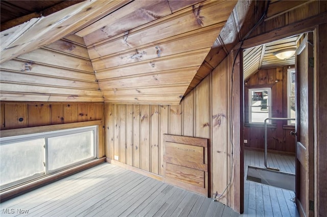 additional living space featuring vaulted ceiling, wood walls, wooden ceiling, and hardwood / wood-style floors