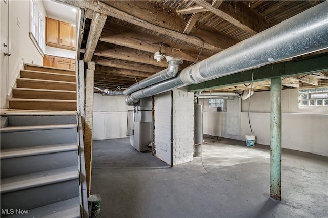 basement featuring water heater, stairway, and heating unit