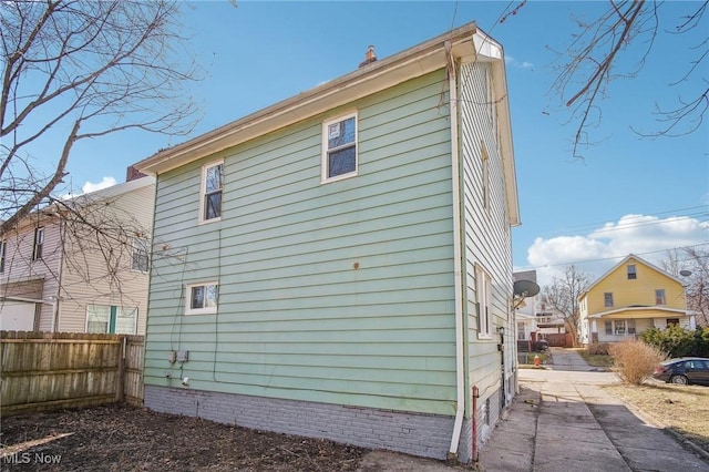 view of side of home featuring fence