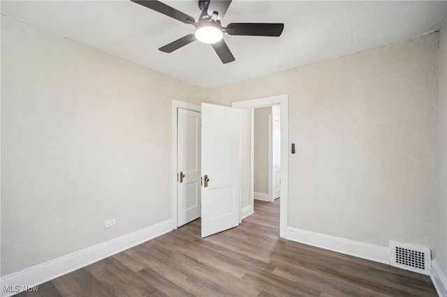 unfurnished bedroom with ceiling fan, visible vents, baseboards, and wood finished floors