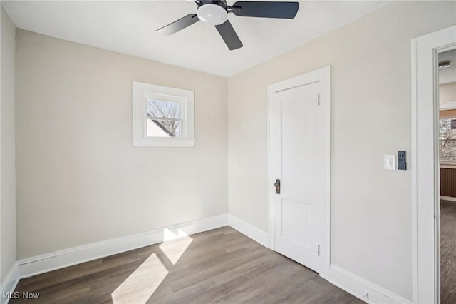 unfurnished bedroom featuring a ceiling fan, baseboards, and wood finished floors