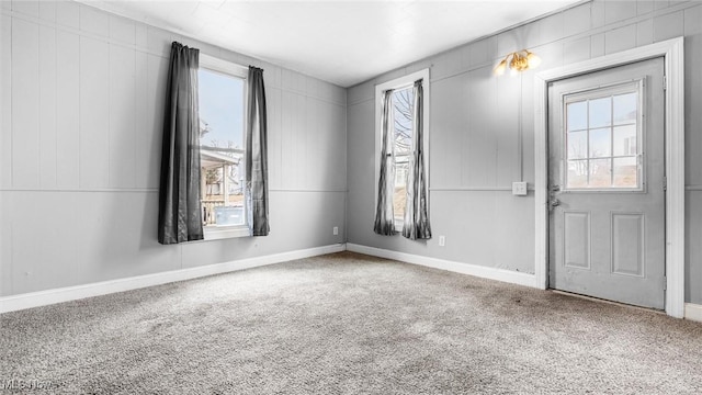 entrance foyer featuring baseboards and carpet flooring