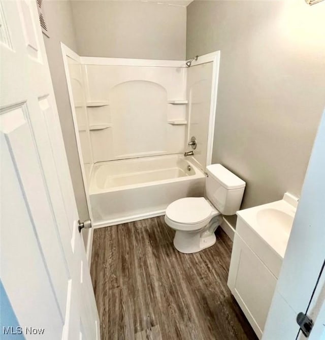 full bath featuring vanity, bathing tub / shower combination, toilet, and wood finished floors