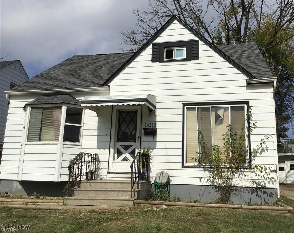 bungalow-style home with roof with shingles