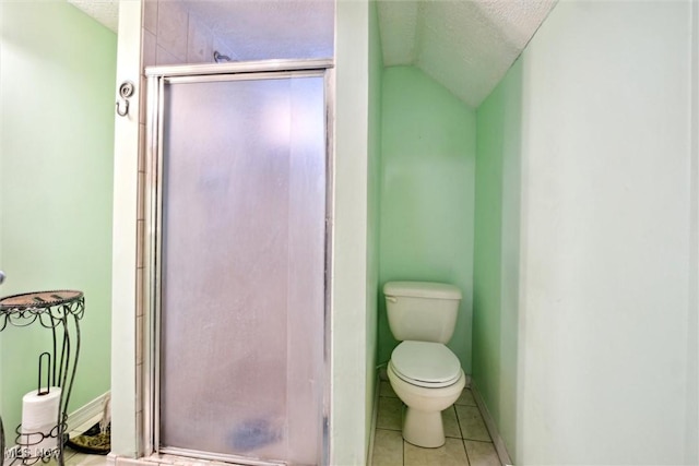 bathroom featuring toilet, tile patterned floors, vaulted ceiling, a textured ceiling, and a shower stall