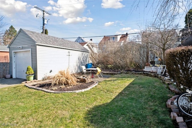 view of yard featuring a garage, driveway, and an outdoor structure