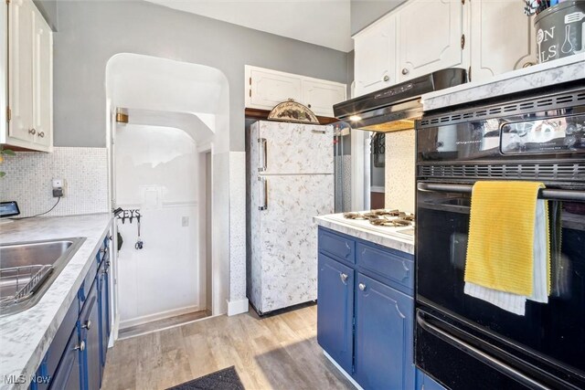 kitchen featuring blue cabinets, white appliances, white cabinets, and light wood-style floors